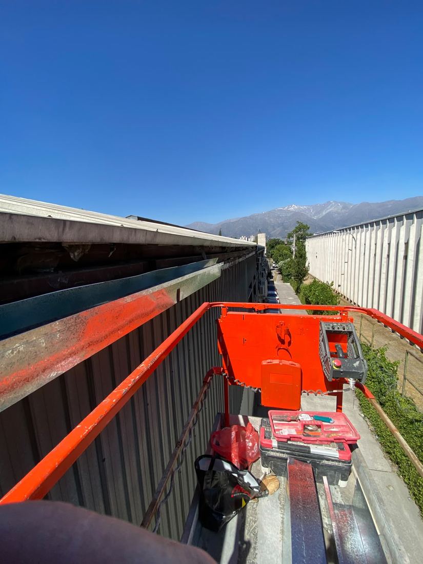Plataforma elevadora junto a galpón con la cordillera de fondo