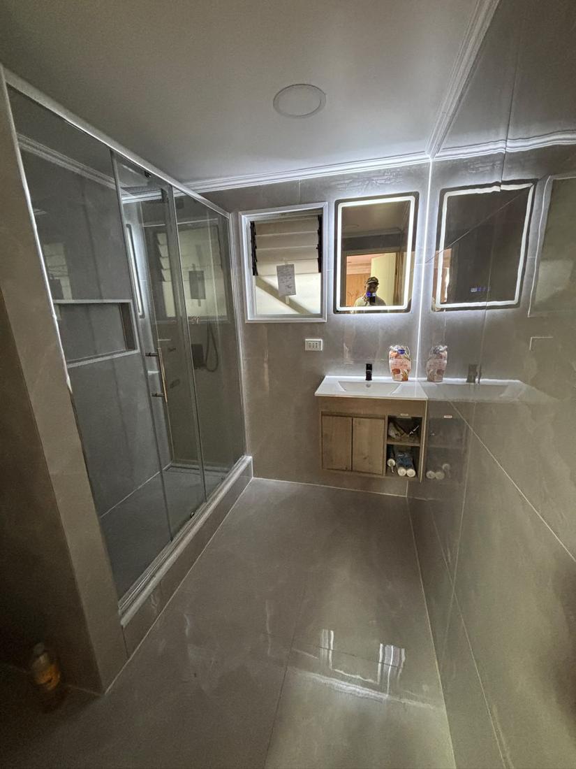 Baño remodelado con mampara y espejo LED